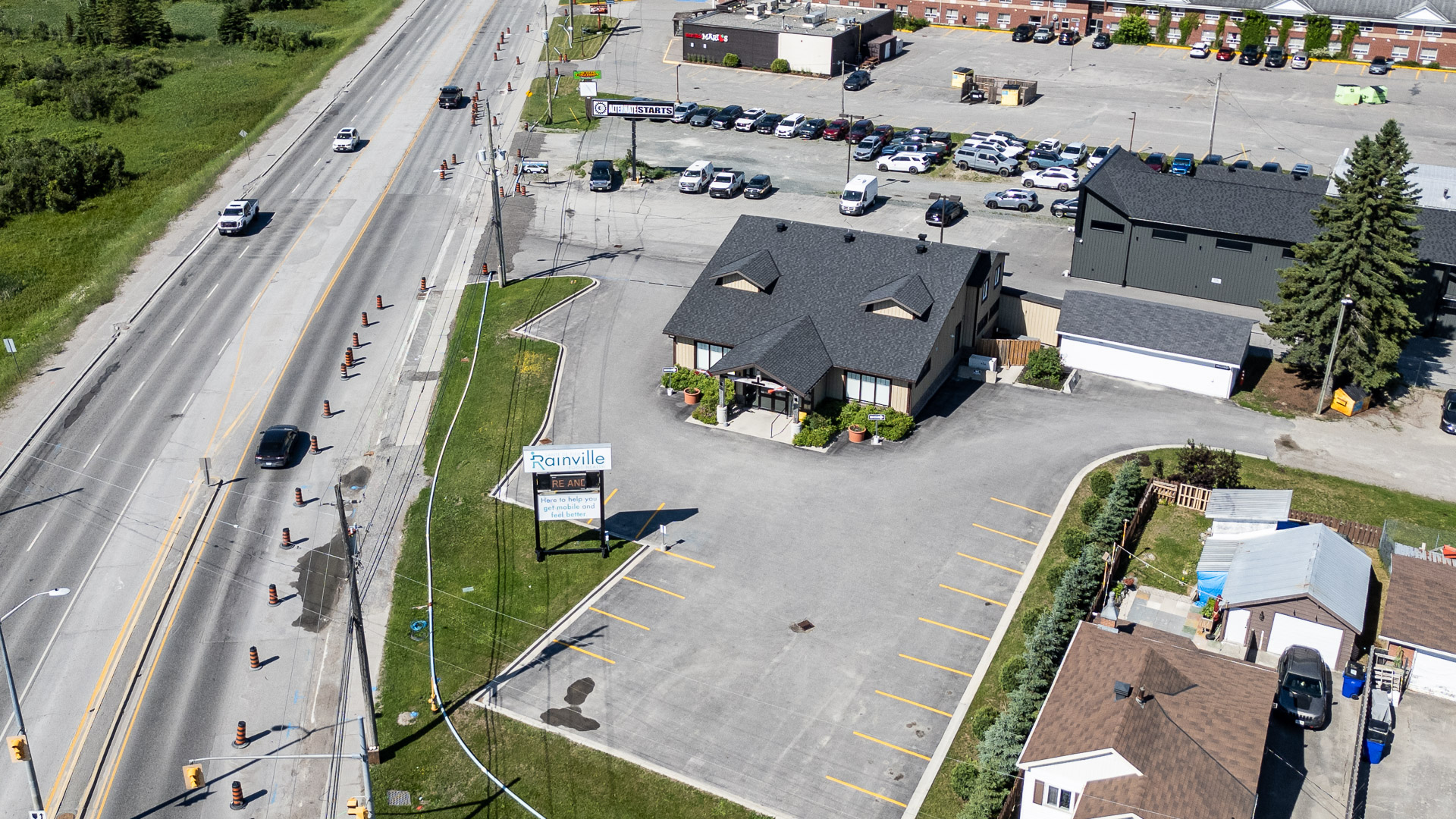 Aerial view of the building, roadside sign and the commercial plaza across Riverside Drive